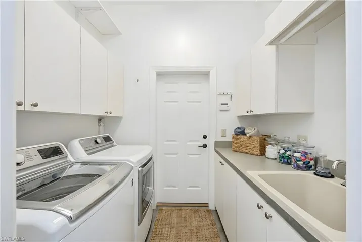 Laundry room featuring independent washer and dryer and cabinet space
