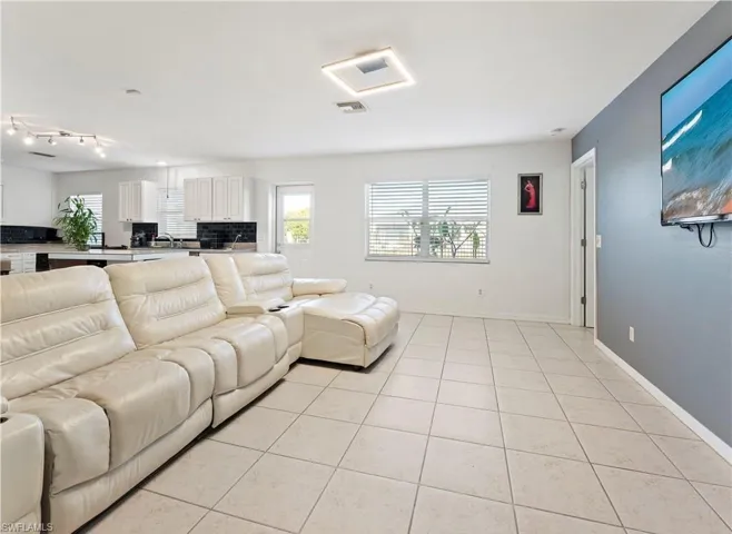 Living room featuring light tile patterned flooring and plenty of natural light
