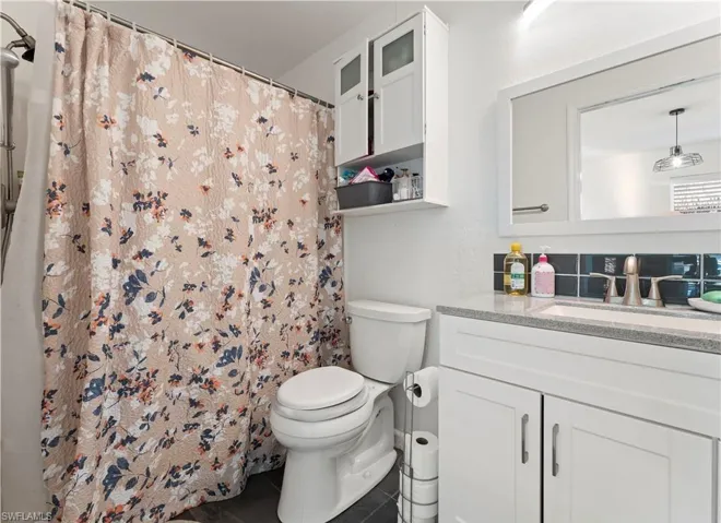 Bathroom with vanity, curtained shower, and tile patterned floors