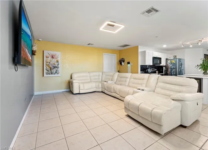 Living area with light tile patterned floors and baseboards