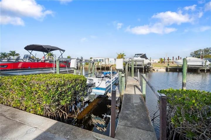 Dock area featuring boat lift and a water view