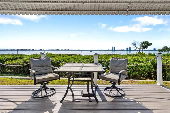 Wooden deck with a water view and outdoor dining space
