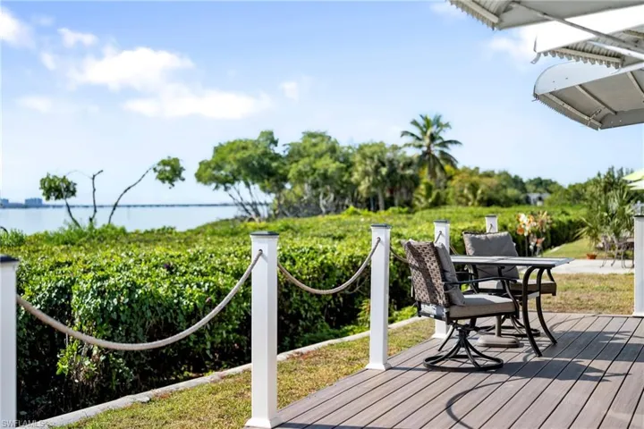 Wooden deck with outdoor dining space and a water view