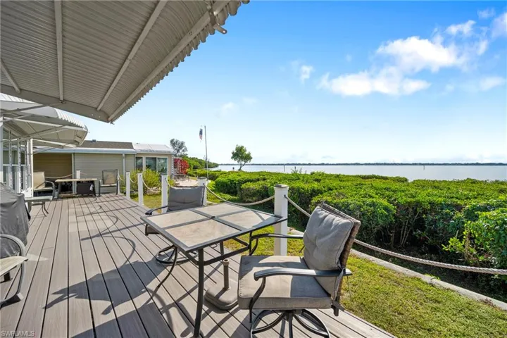 Wooden deck with outdoor dining space and a water view
