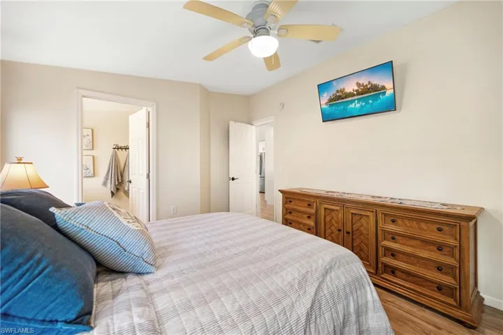 Bedroom featuring wood finished floors, ceiling fan, and connected bathroom
