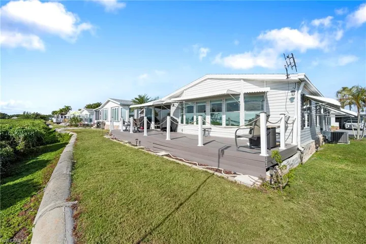 Back of property featuring a deck and a lawn