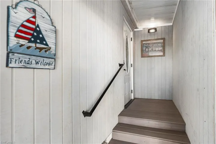 Stairs featuring hardwood / wood-style flooring and wooden walls