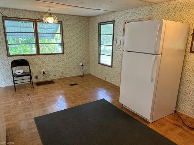 Kitchen featuring a healthy amount of sunlight, white refrigerator, and parquet floors