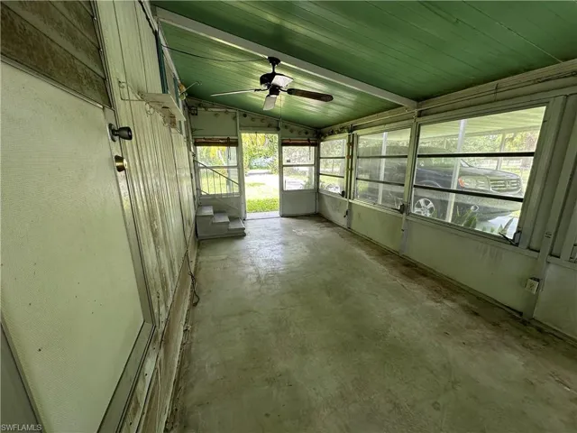 Unfurnished sunroom with lofted ceiling and ceiling fan