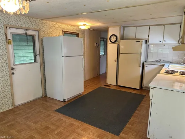 Kitchen featuring white refrigerator and light parquet flooring
