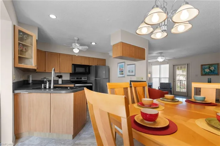 Dining area featuring ceiling fan, a textured ceiling, and hanging lights