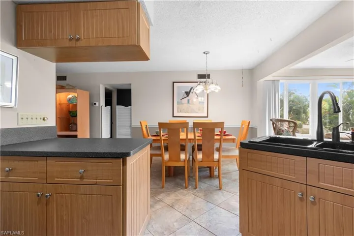 Kitchen featuring dark countertops, a textured ceiling, a peninsula, light tile patterned flooring