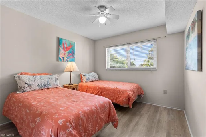 Bedroom featuring wood finished floors, a ceiling fan, and a textured ceiling