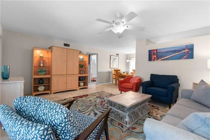 Living area with ceiling fan and light tile patterned flooring
