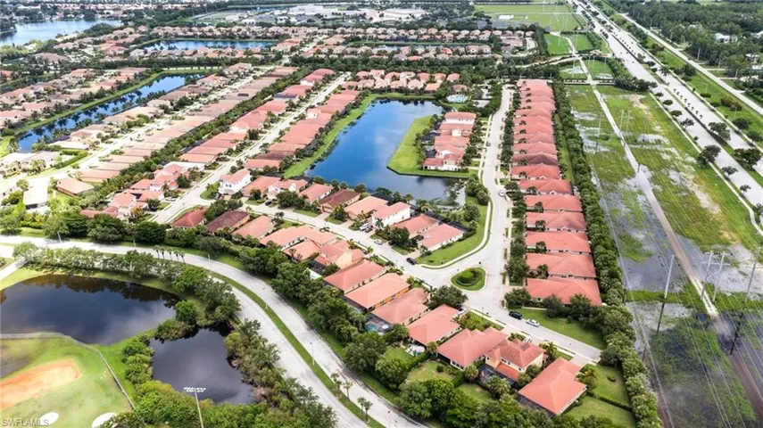 Aerial view of property and surrounding area featuring a nearby body of water and nearby suburban area