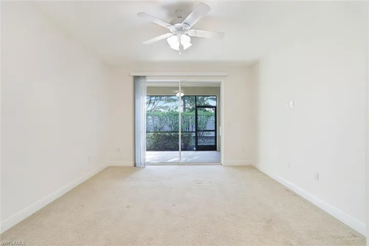 Empty room featuring light colored carpet and ceiling fan