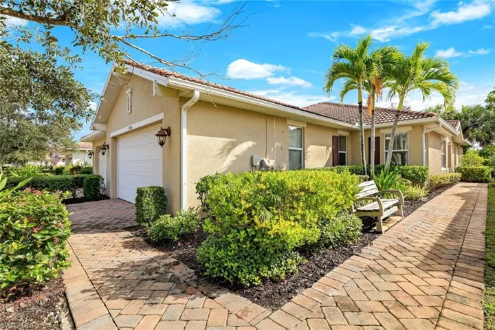 View of front of house featuring stucco siding, a tile roof, and a garage