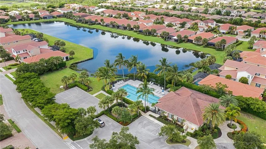 Aerial perspective of suburban area featuring a nearby body of water and a pool area