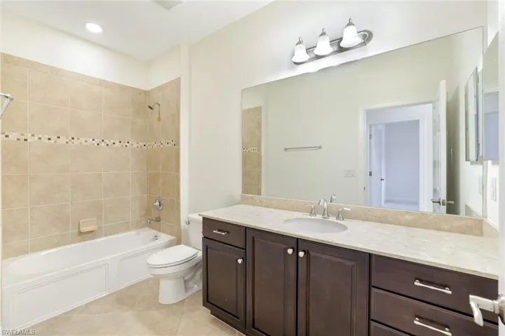 Bathroom featuring  shower combination, light tile patterned flooring, vanity, and recessed lighting
