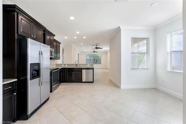 Kitchen featuring appliances with stainless steel finishes, light tile patterned floors, recessed lighting, light stone counters, and a peninsula