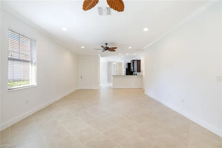 Unfurnished living room with crown molding, recessed lighting, light tile patterned floors, and ceiling fan