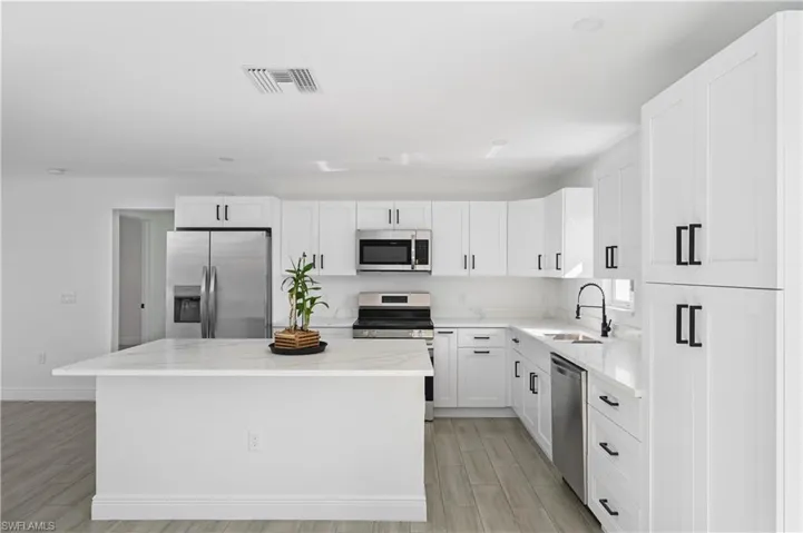 Kitchen with stainless steel appliances, stone counters