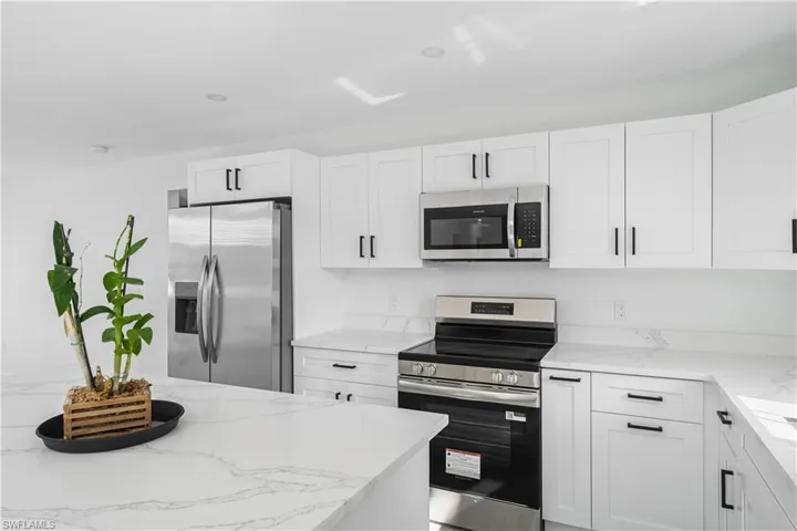 Kitchen with stainless steel appliances, stone counters
