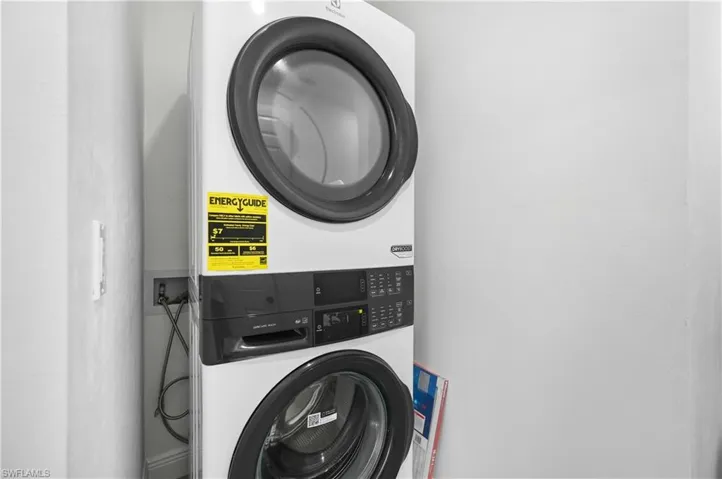 Laundry room featuring stacked washing machine and dryer