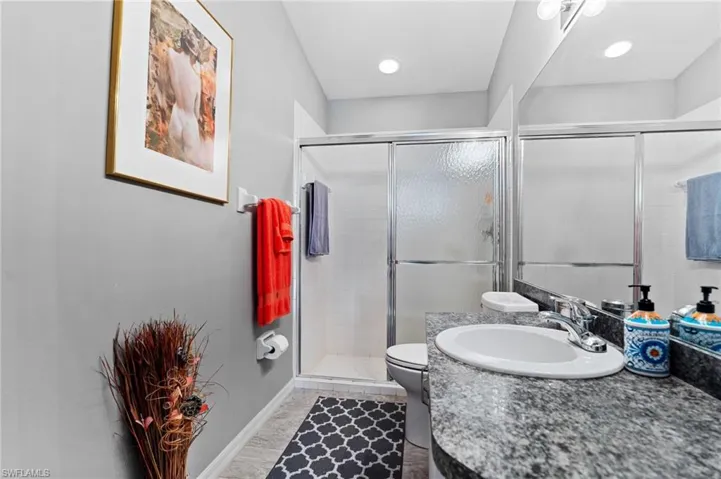 Bathroom with vanity, a walk in shower, and light tile patterned floors