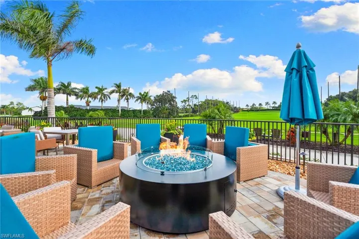Wooden deck featuring an outdoor living space with a fire pit, view of golf course, and a patio area