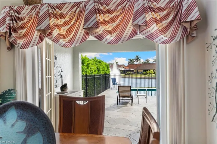 Balcony with a water view and view of pool area