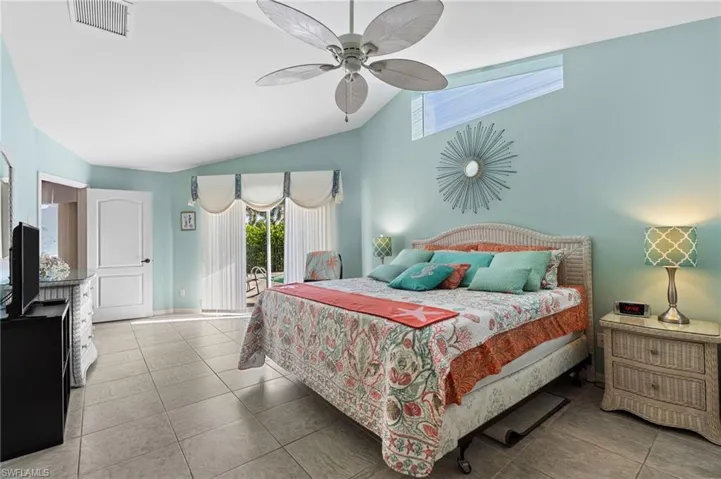 Bedroom with access to exterior, tile patterned floors, a ceiling fan, and high vaulted ceiling