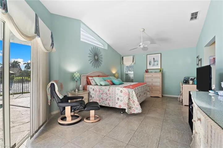 Bedroom featuring access to outside, a ceiling fan, light tile patterned floors, and high vaulted ceiling