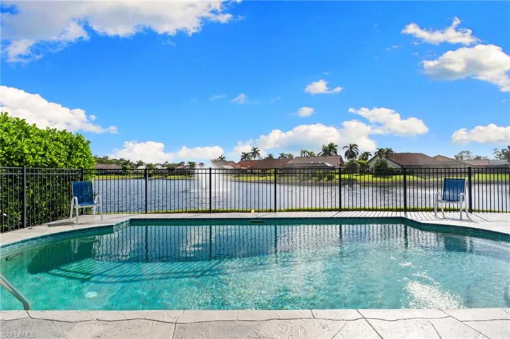 View of swimming pool with a water view, a residential view, and a patio area