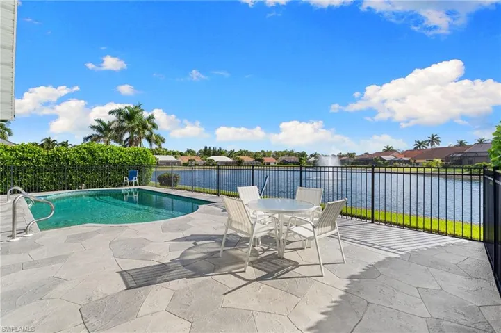 View of swimming pool featuring a water view, outdoor dining space, a patio, and a residential view