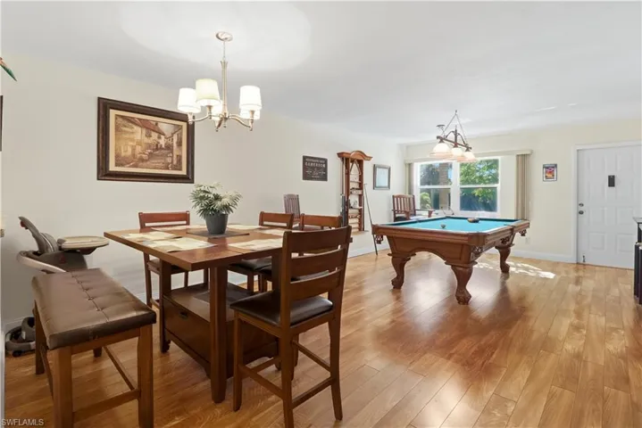 Dining space featuring light wood-style flooring, billiards table, and a chandelier