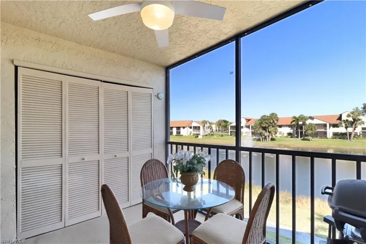 Sunroom / solarium featuring ceiling fan, a water view, a balcony, and outdoor dining space