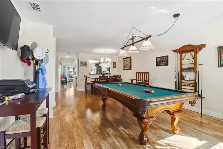 Playroom with light wood-style floors, billiards table, and a chandelier