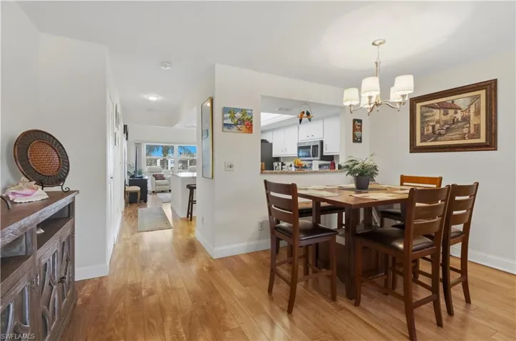 Dining area with light wood finished floors and a chandelier