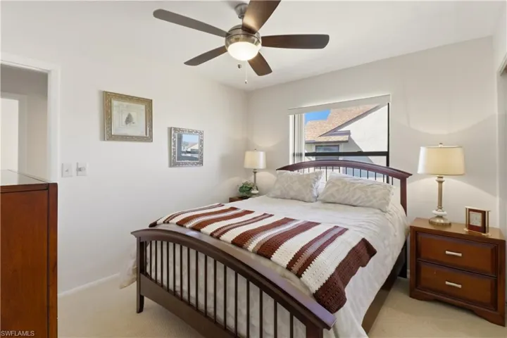 Bedroom with a ceiling fan and light colored carpet