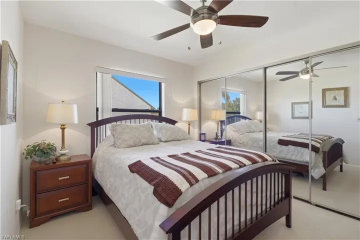 Carpeted bedroom featuring ceiling fan and a closet
