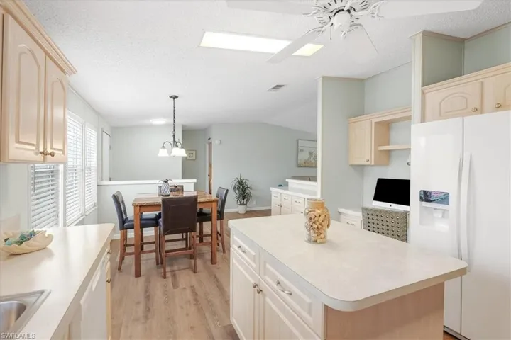 Kitchen featuring light-toned cabinetry, a built-in refrigerator, and a central island