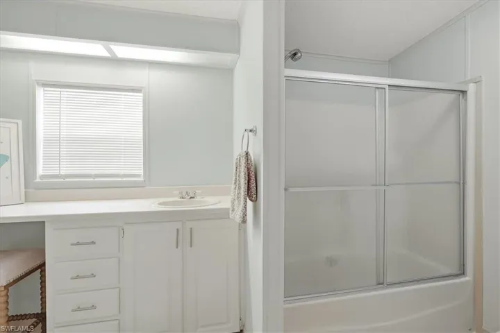 White vanity with a built-in sink, multiple drawers, and cabinet storage