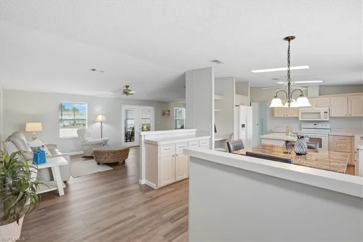 Open-concept living area featuring wood-finish flooring, recessed lighting, and a ceiling fan