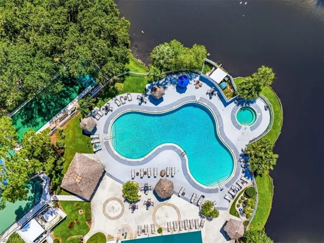 Free-form swimming pool with integrated spa, surrounded by a paved deck