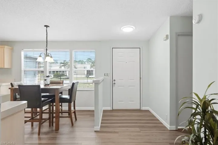 Wood-finish flooring throughout, light-toned wall paint, and multiple windows with blinds