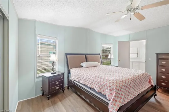 Wood-finish flooring with light blue wall panels and a textured ceiling