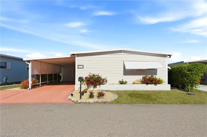 View of front of house featuring a front yard, driveway, and an attached carport