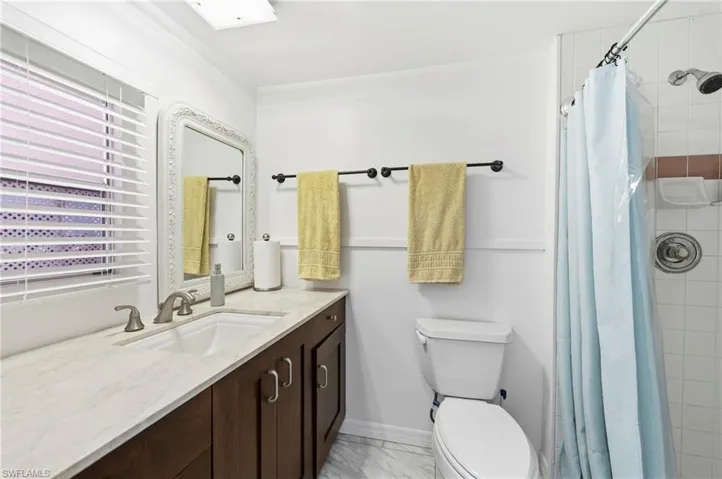Bathroom with a stall shower, vanity, and light marble finish flooring