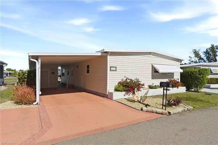 View of front of property featuring an attached carport and driveway